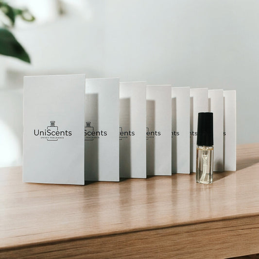 A series of white vials labeled 'UniScents' containing perfume samples, arranged on a wooden surface, with one vial placed in front of the others.